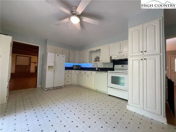 a kitchen with granite countertop white cabinets and white appliances