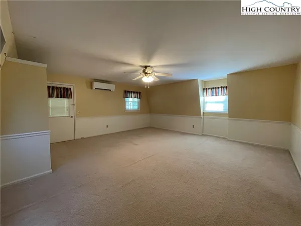 an empty room with a ceiling fan and window