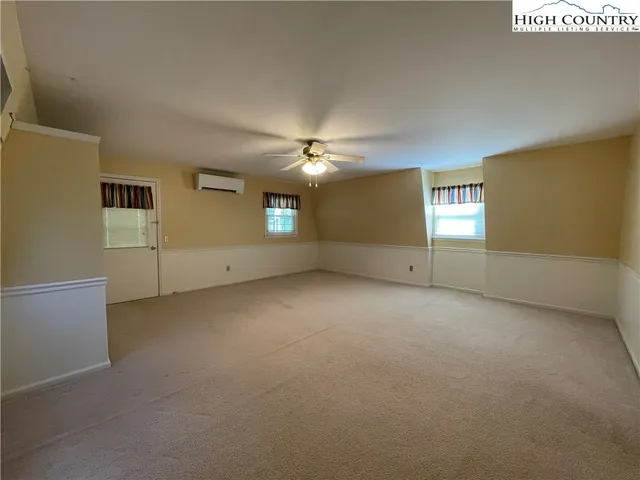 an empty room with a ceiling fan and window