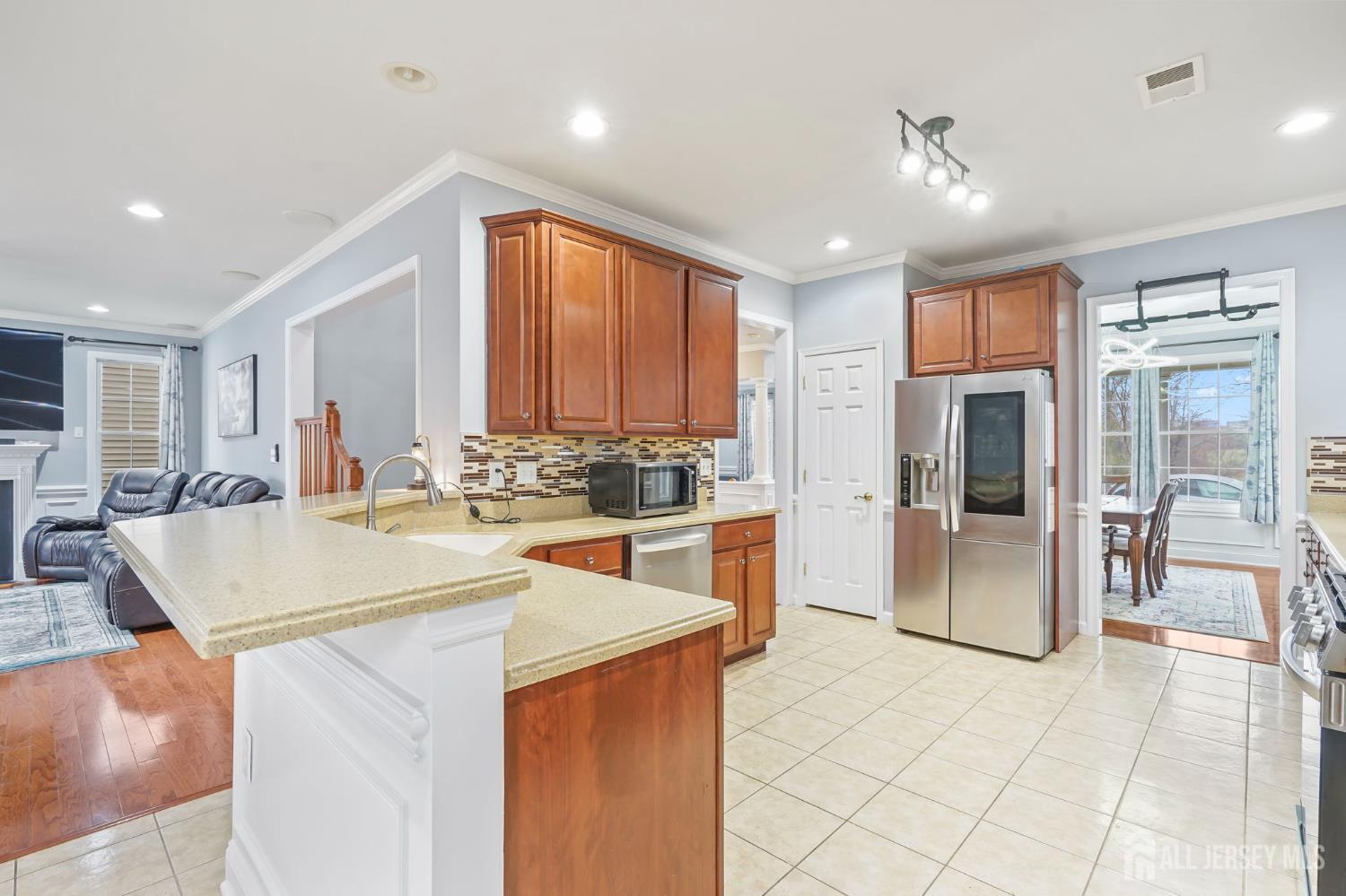 54 Harness Way Chesterfield, NJ 08515 - Photo 18 of 41 a kitchen with stainless steel appliances a sink a stove a refrigerator cabinets and living room view