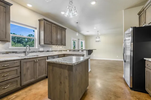 a bedroom with a large bed a chandelier and a window