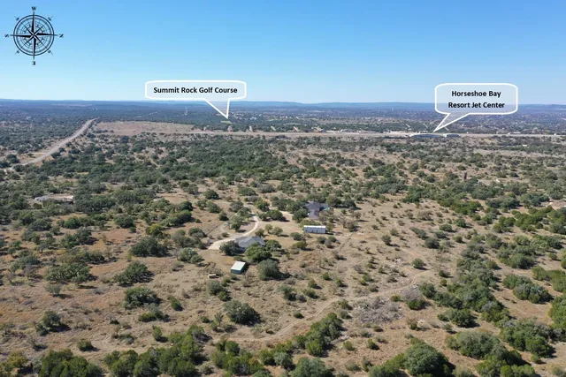 an aerial view of house with yard and mountain view in back