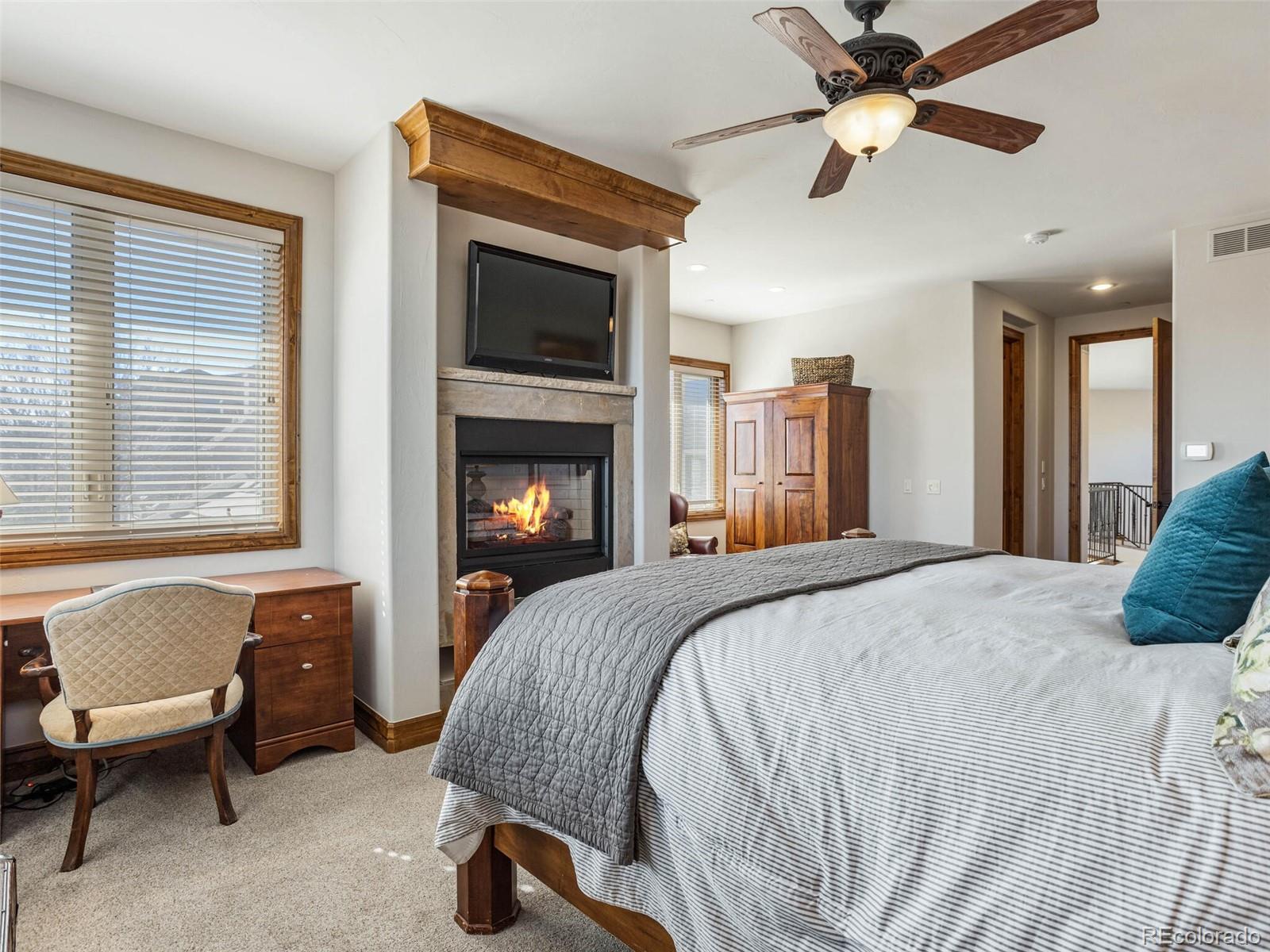 1176 Buffalo Ridge Road Castle Pines, CO 80108 - Photo 19 of 37 a bedroom with a bed and a fireplace
