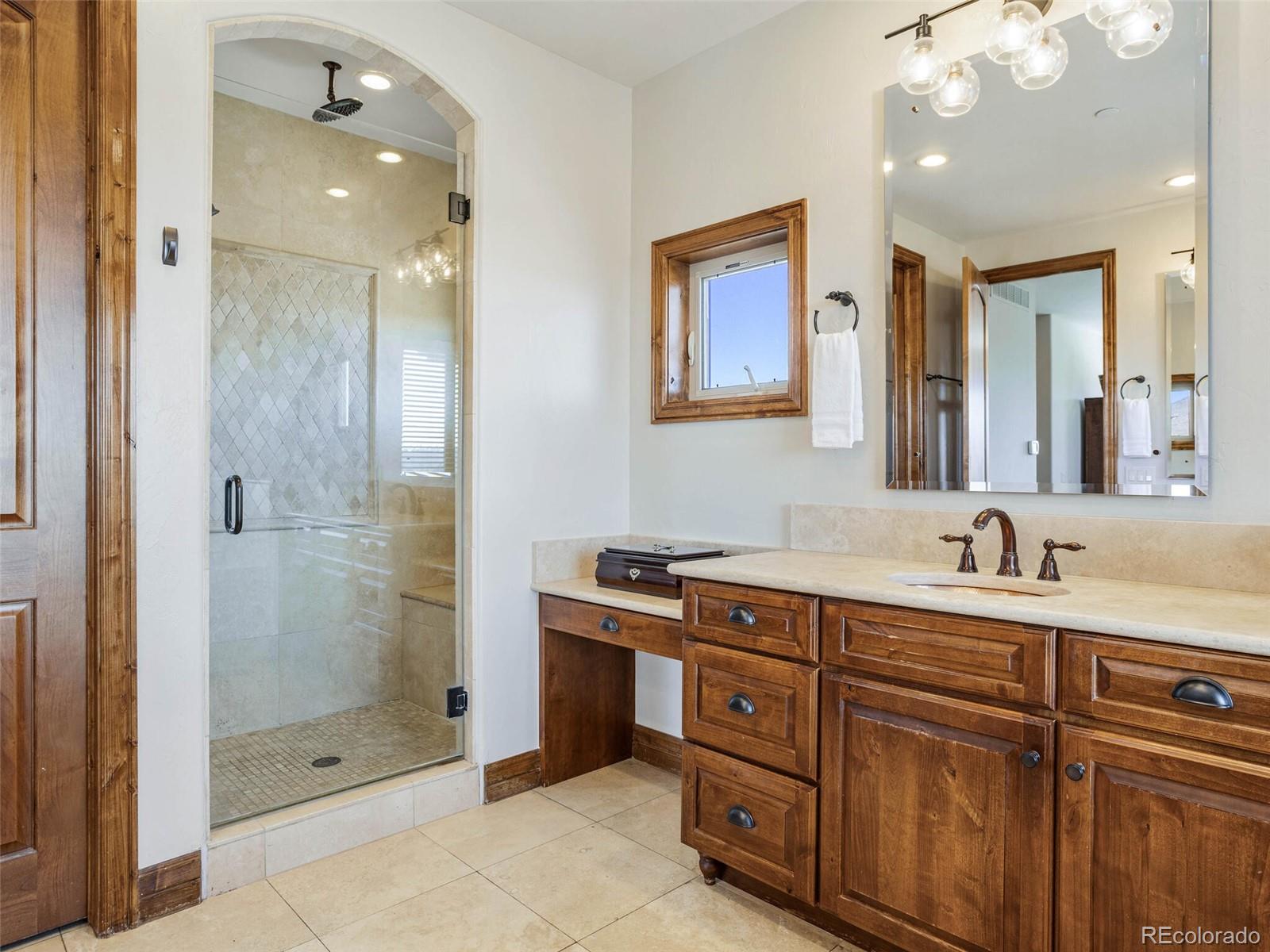 1176 Buffalo Ridge Road Castle Pines, CO 80108 - Photo 21 of 37 a bathroom with a sink vanity granite shower and a mirror