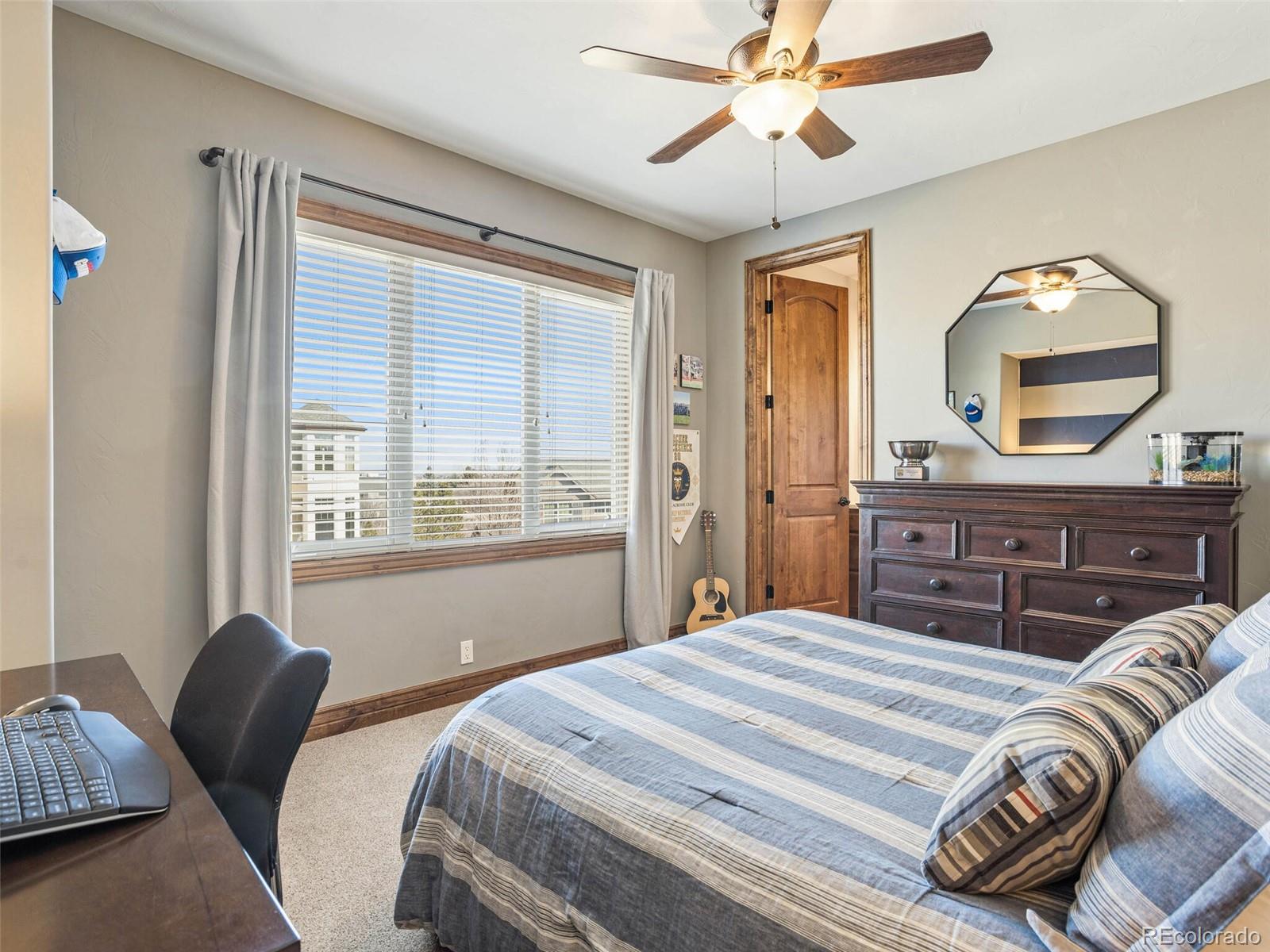 1176 Buffalo Ridge Road Castle Pines, CO 80108 - Photo 22 of 37 a bedroom with bed and a window