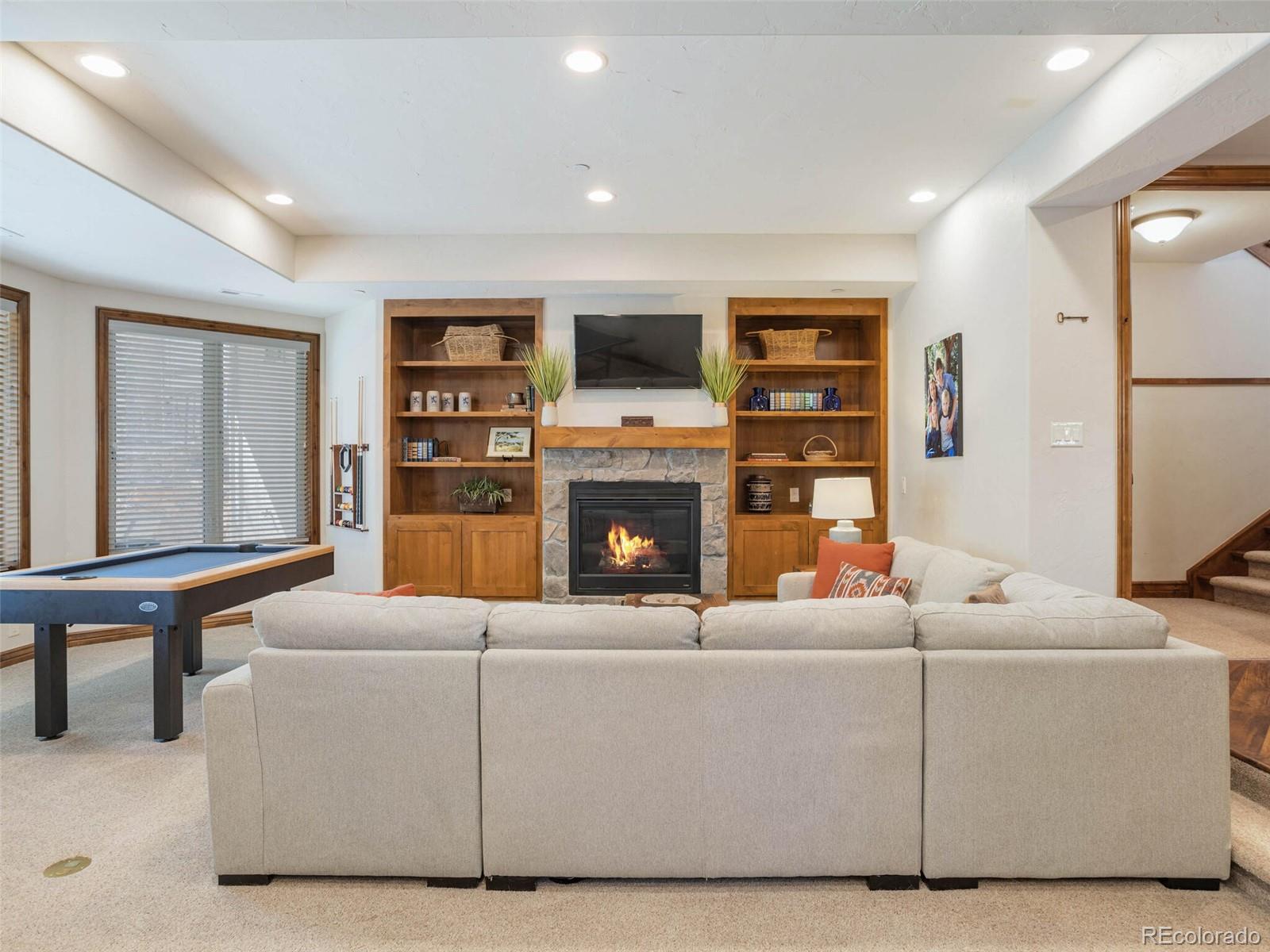 1176 Buffalo Ridge Road Castle Pines, CO 80108 - Photo 29 of 37 a living room with furniture a flat screen tv and a fireplace