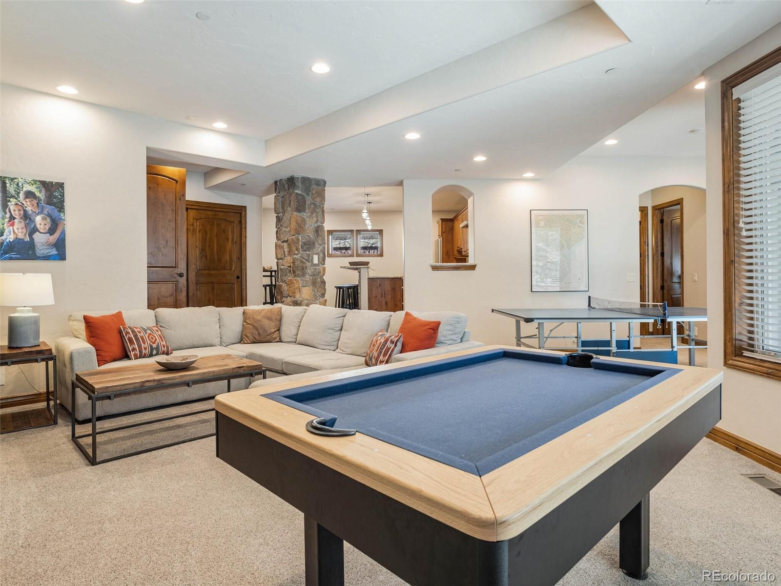 1176 Buffalo Ridge Road Castle Pines, CO 80108 - Photo 30 of 37 a living room with stainless steel appliances furniture a rug and a kitchen view