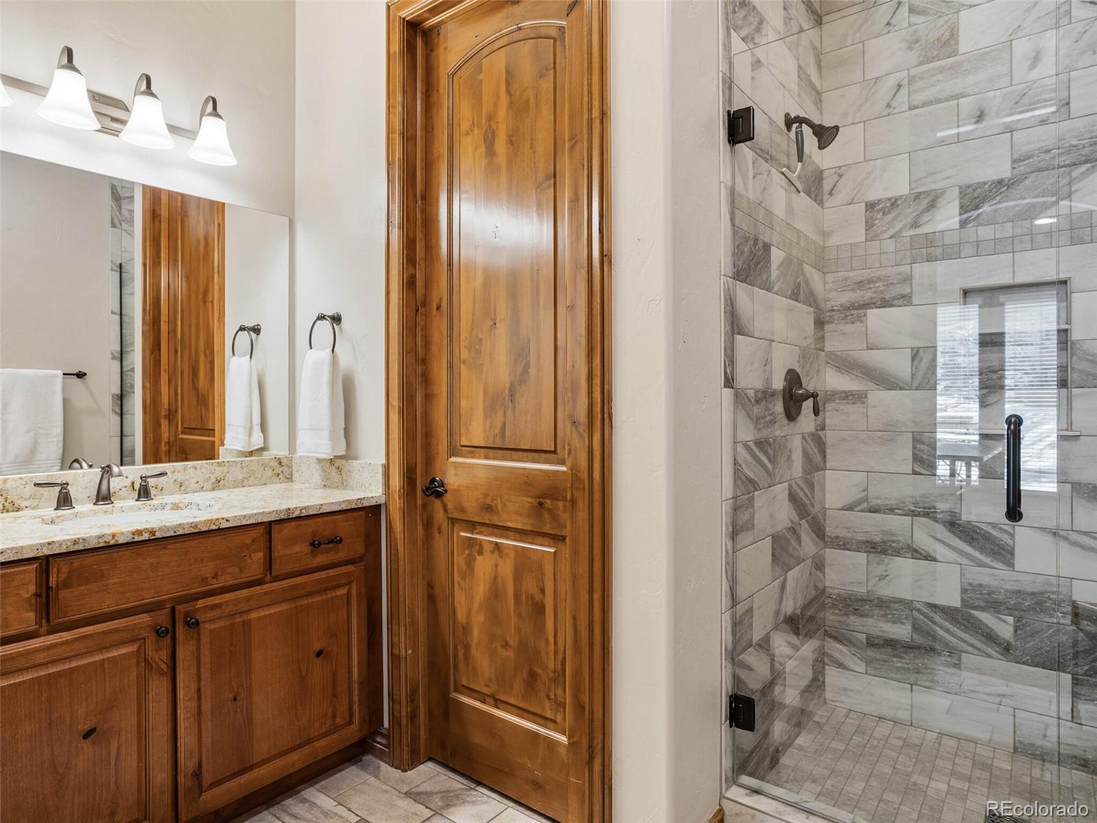 1176 Buffalo Ridge Road Castle Pines, CO 80108 - Photo 32 of 37 a bathroom with a double vanity sink and a mirror