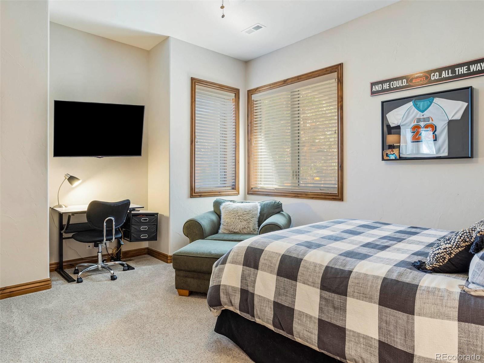 1176 Buffalo Ridge Road Castle Pines, CO 80108 - Photo 33 of 37 a bedroom with a bed and a flat screen tv