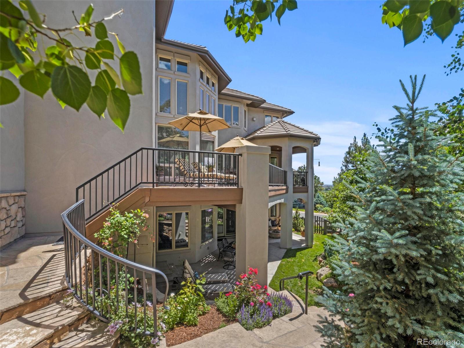 1176 Buffalo Ridge Road Castle Pines, CO 80108 - Photo 35 of 37 a view of a brick house with a flower garden