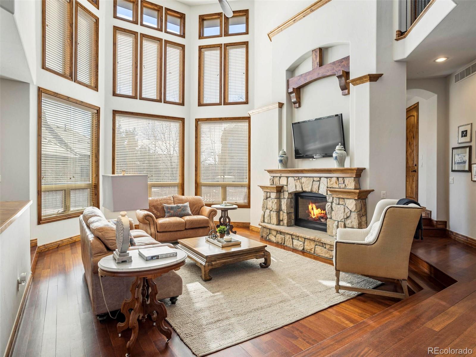 1176 Buffalo Ridge Road Castle Pines, CO 80108 - Photo 4 of 37 a living room with furniture a fireplace and a flat screen tv