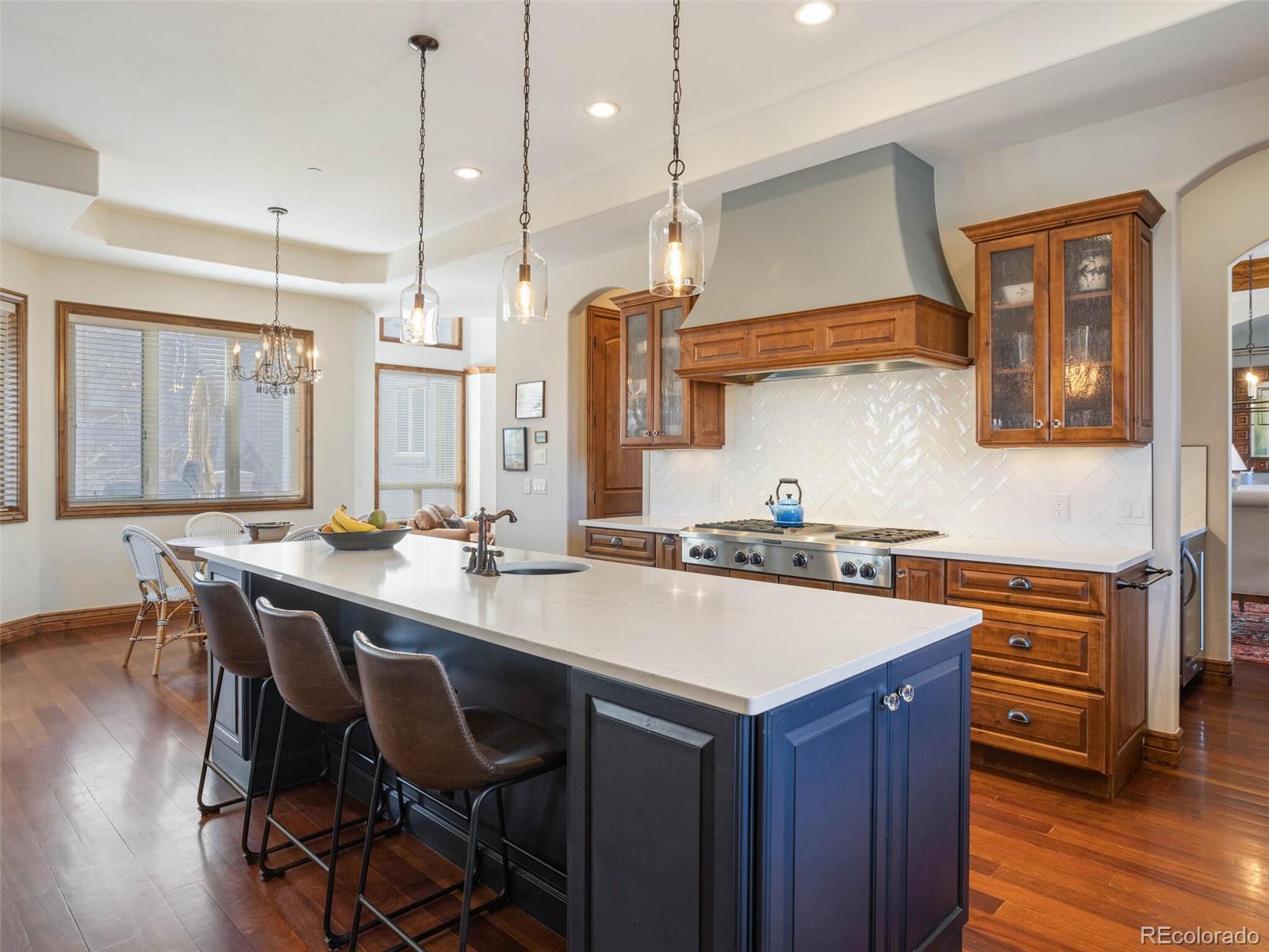 1176 Buffalo Ridge Road Castle Pines, CO 80108 - Photo 7 of 37 a kitchen with a stove a sink a dining table and chairs