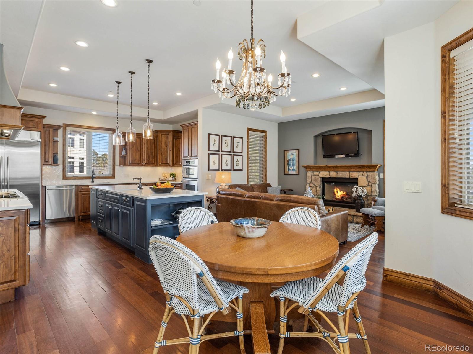 1176 Buffalo Ridge Road Castle Pines, CO 80108 - Photo 9 of 37 a view of a dining room with furniture a kitchen and chandelier