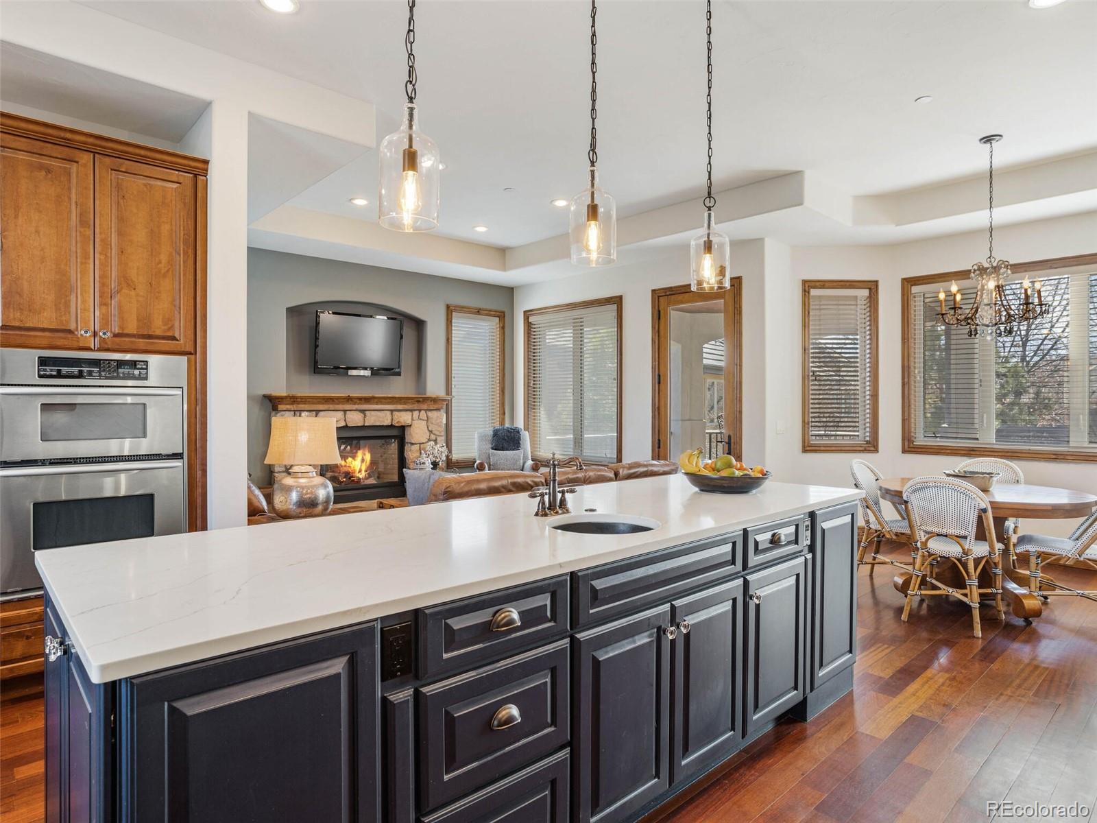 1176 Buffalo Ridge Road Castle Pines, CO 80108 - Photo 10 of 37 a kitchen with a sink a stove and chairs