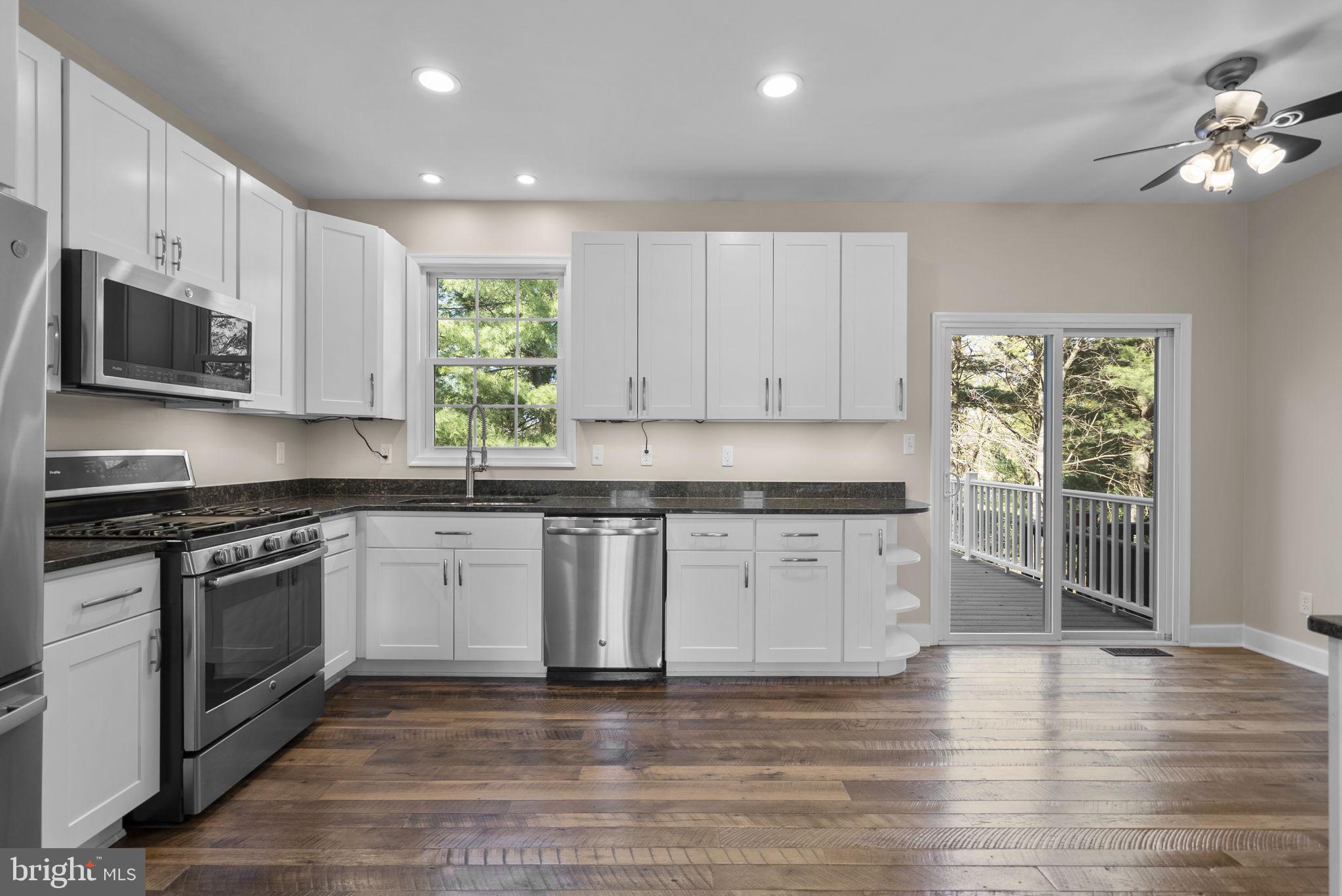 1304 Hill Born Drive Hanover, MD 21076 - Photo 7 of 47 a kitchen with stainless steel appliances granite countertop a stove a sink and a microwave