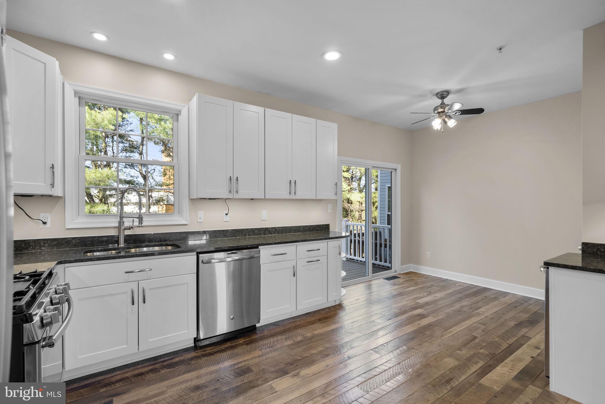 1304 Hill Born Drive Hanover, MD 21076 - Photo 9 of 47 a kitchen with granite countertop a stove a sink and white cabinets with wooden floor