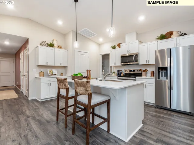 a kitchen with stainless steel appliances a stove a sink a refrigerator and a microwave