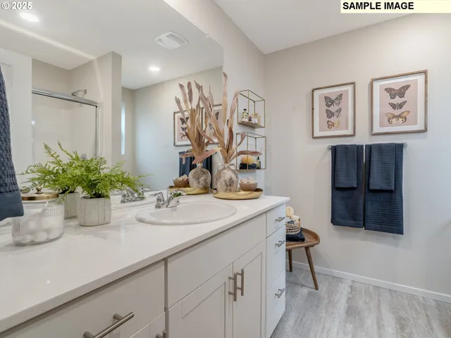 a bathroom with a sink a mirror and a potted plant