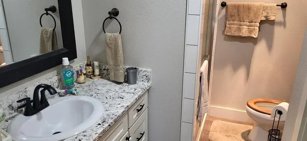 a bathroom with a granite countertop sink and a mirror