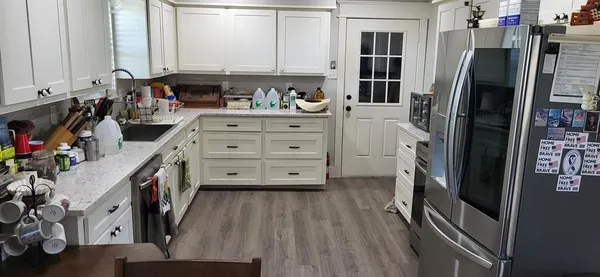 a kitchen with stainless steel appliances a refrigerator sink and cabinets