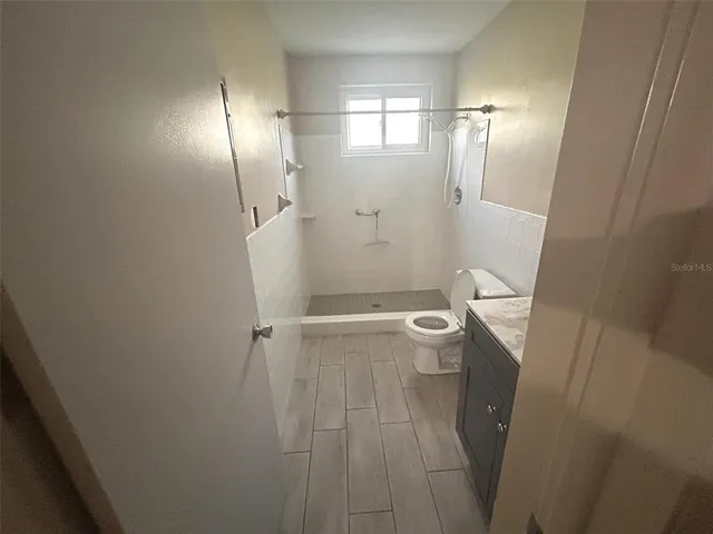 a white toilet sitting next to a bathroom sink and a shower