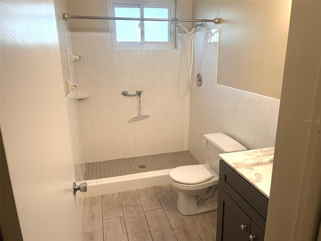 2402 Ecuadorian Way, Unit 18 Clearwater, FL 33763 - Photo 20 of 55 a white toilet sitting next to a bathroom sink and a shower