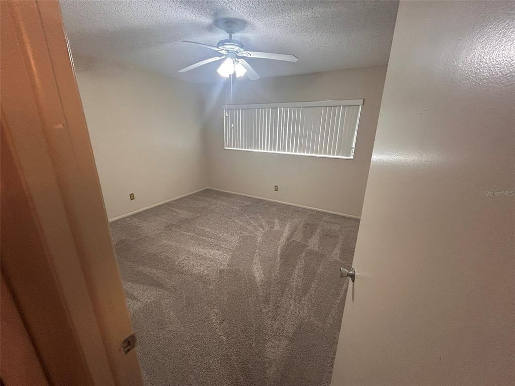 2402 Ecuadorian Way, Unit 18 Clearwater, FL 33763 - Photo 27 of 55 an empty room with windows and fan