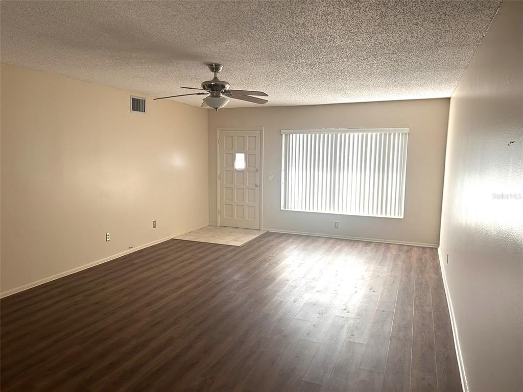 2402 Ecuadorian Way, Unit 18 Clearwater, FL 33763 - Photo 6 of 55 wooden floor in an empty room with a window