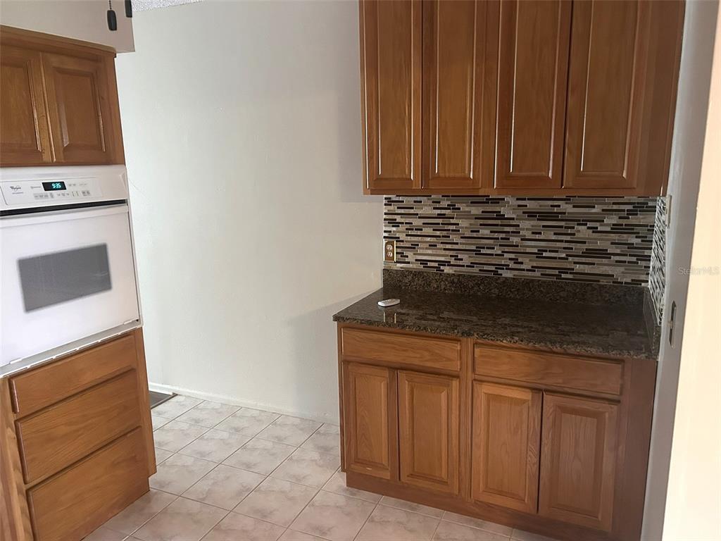 2402 Ecuadorian Way, Unit 18 Clearwater, FL 33763 - Photo 8 of 55 a kitchen with granite countertop cabinets and sink