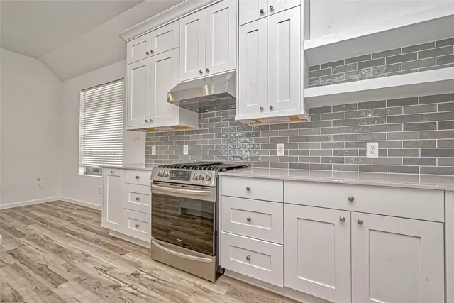 a kitchen with granite countertop white cabinets and white appliances
