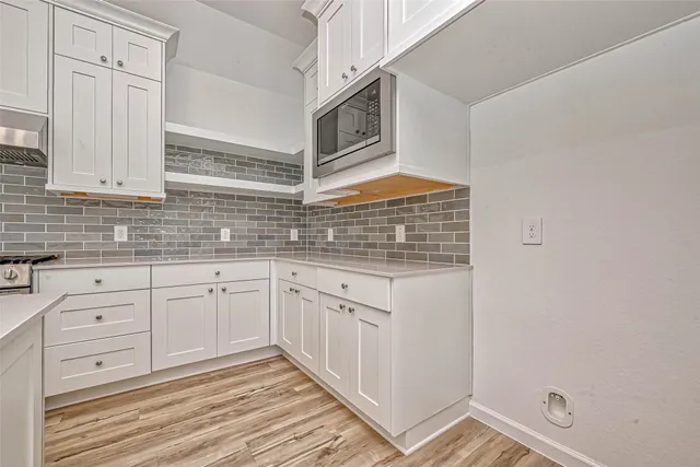 a kitchen with granite countertop white cabinets and white appliances