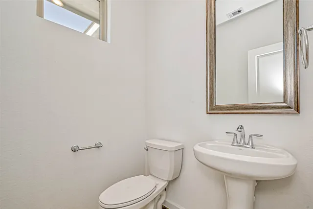a bathroom with a sink toilet and mirror