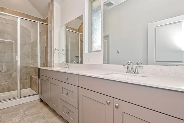 a bathroom with double vanity sinks and a mirror