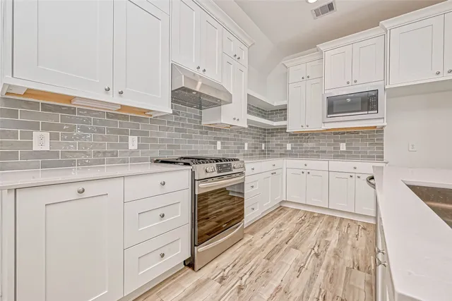 a kitchen with granite countertop white cabinets and white appliances