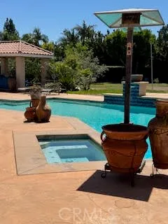 a swimming pool with barbeque oven outdoor seating yard and green space