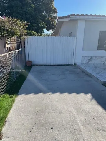 a view of backyard space and wooden fence