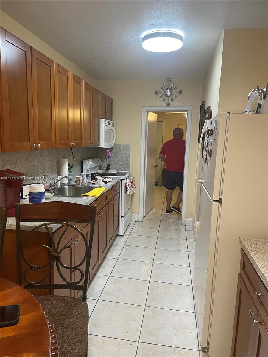 Hialeah Acres Hialeah, FL 33012 - Photo 8 of 9 a kitchen with a sink a stove and a refrigerator