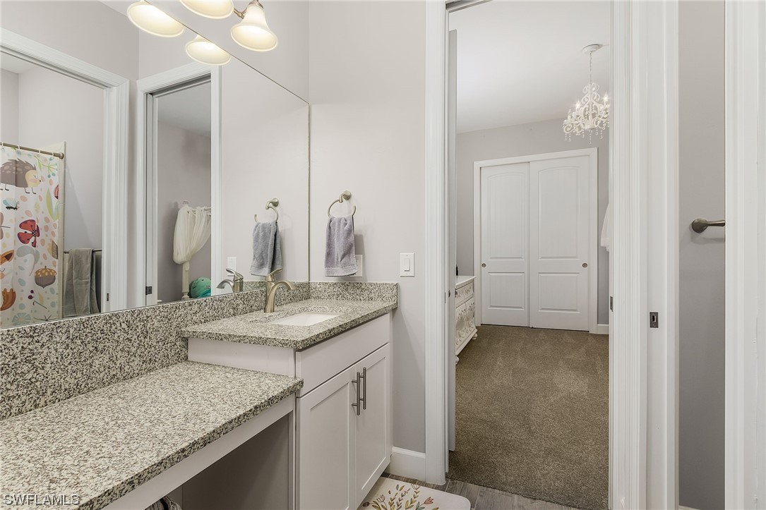 17405 Cabrini Way Estero, FL 33928 - Photo 22 of 34 a bathroom with a granite countertop sink and a mirror