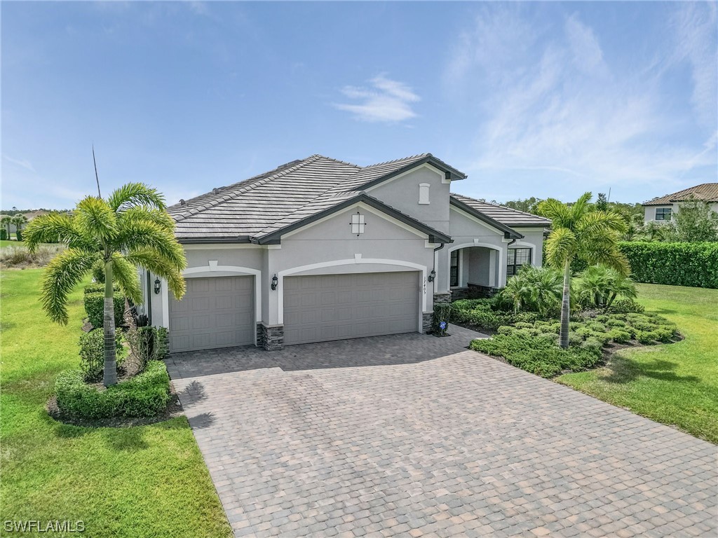 17405 Cabrini Way Estero, FL 33928 - Photo 34 of 34 a front view of a house with a garden and garage