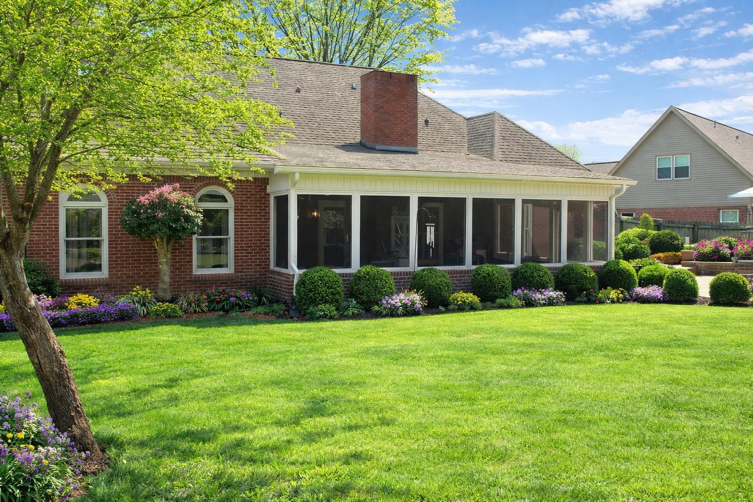 175 Windale Drive Jackson, TN 38305 - Photo 2 of 25 Back of property featuring a lawn, a shingled roof, a chimney, brick siding, and a sunroom