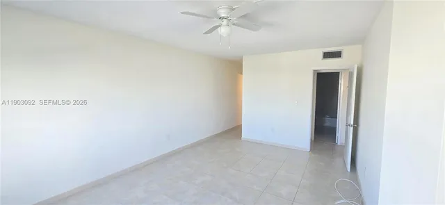 an empty room with a ceiling fan and bathroom