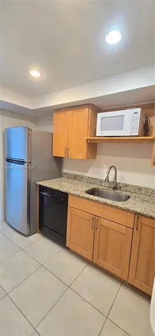 a large kitchen with granite countertop a sink and cabinets