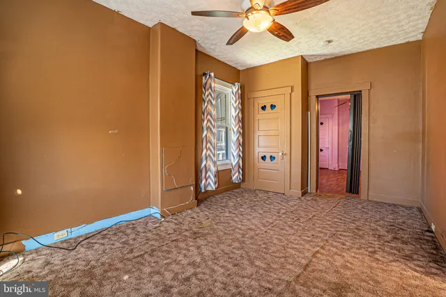 a view of a livingroom with a chandelier fan and a bathroom