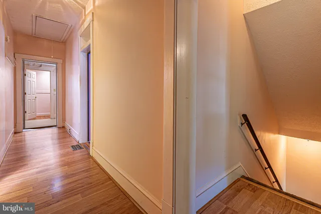 a view of a hallway with wooden floor