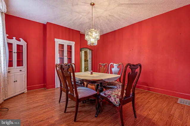 a dining room with furniture a chandelier and wooden floor