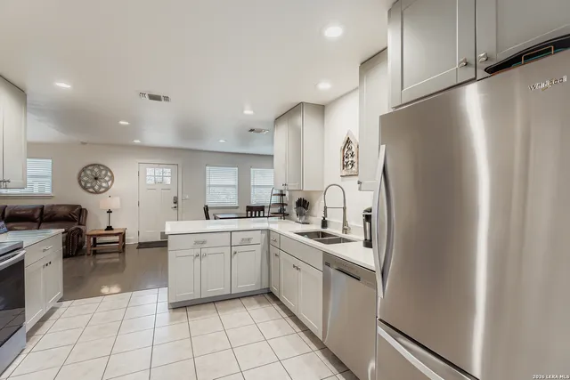 a kitchen with white cabinets stainless steel appliances and a sink