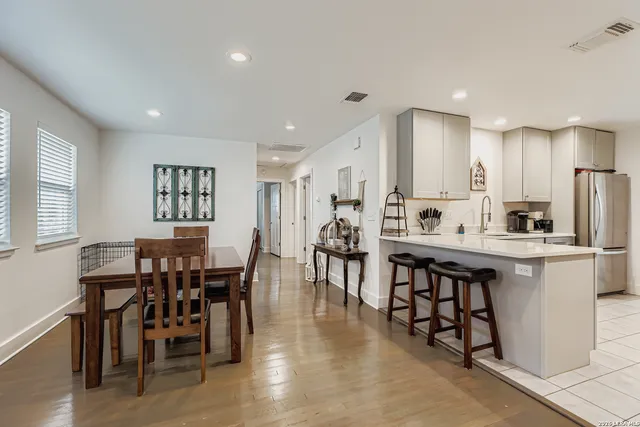 a large kitchen with white cabinets and stainless steel appliances