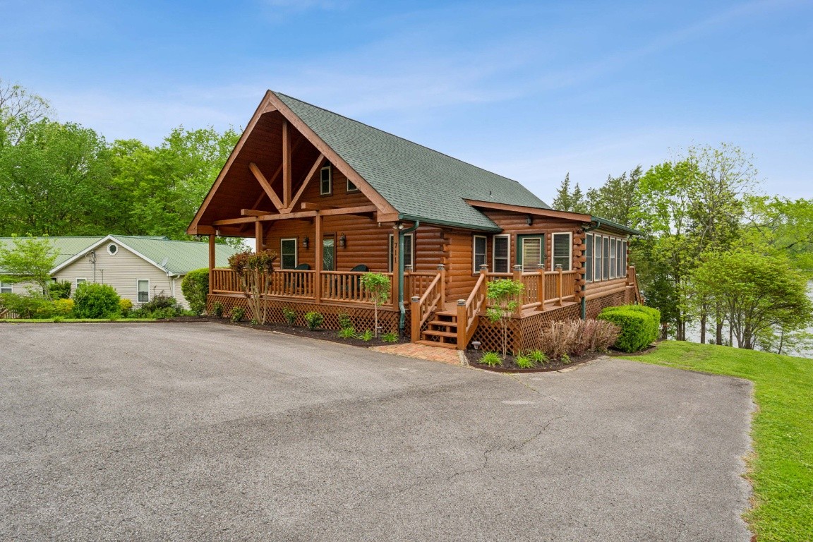 a view of an house with backyard and bushes