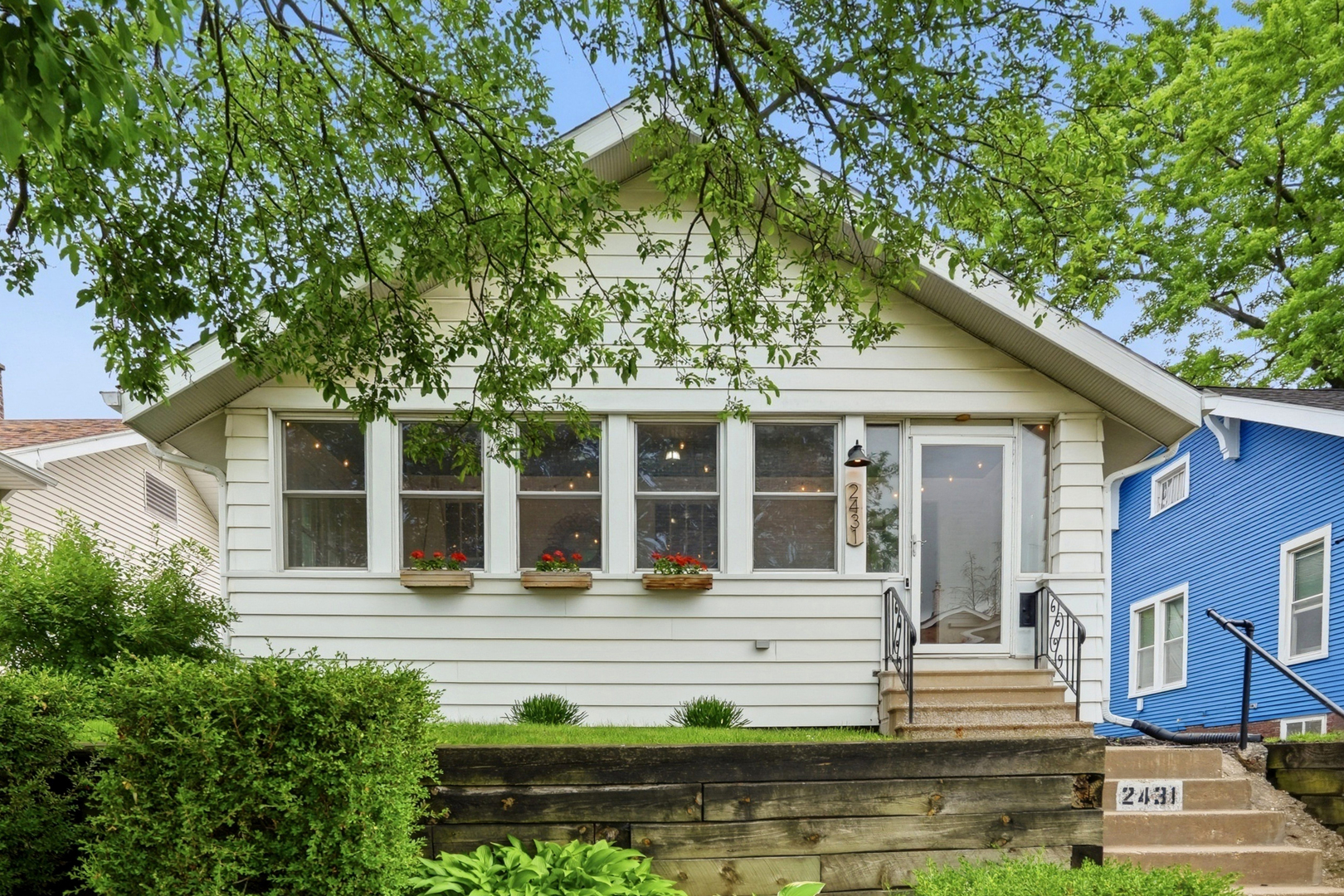 2431 14th Avenue Moline, IL 61265 - Photo 2 of 37 a view of a white house with large windows and a small yard