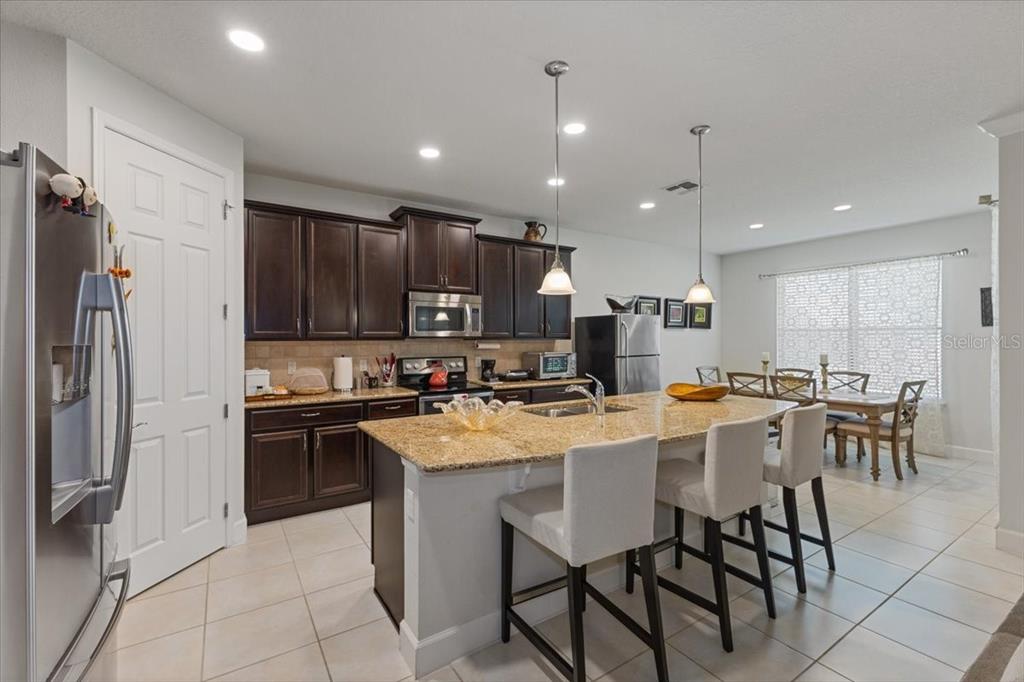 7180 Beek Street Windermere, FL 34786 - Photo 3 of 33 a kitchen with kitchen island a table and chairs